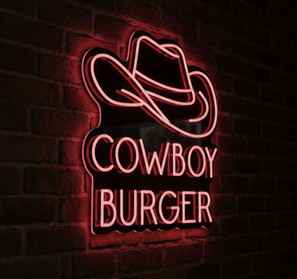 A neon sign for 'Cowboy Burger' featuring a cowboy hat outline above the words 'COWBOY BURGER' in glowing pink letters, mounted on a dark brick wall.